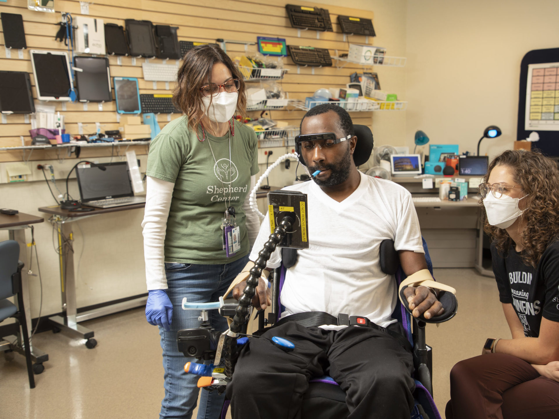 Shepherd staff assisting a patient with assistive technology device.