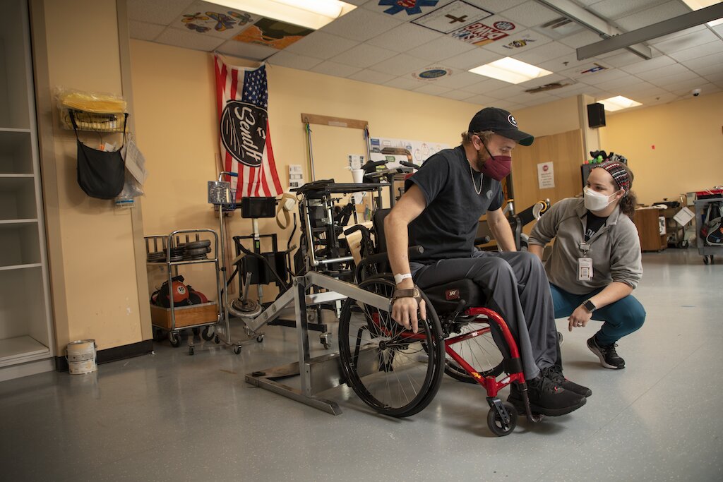 Shepherd staff member assesses on a patient who is sitting in a wheelchair.