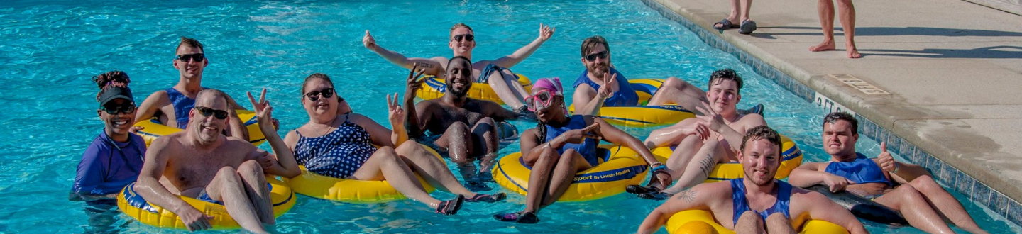 Shepherd Center patients and volunteers on pool floats in the pool.