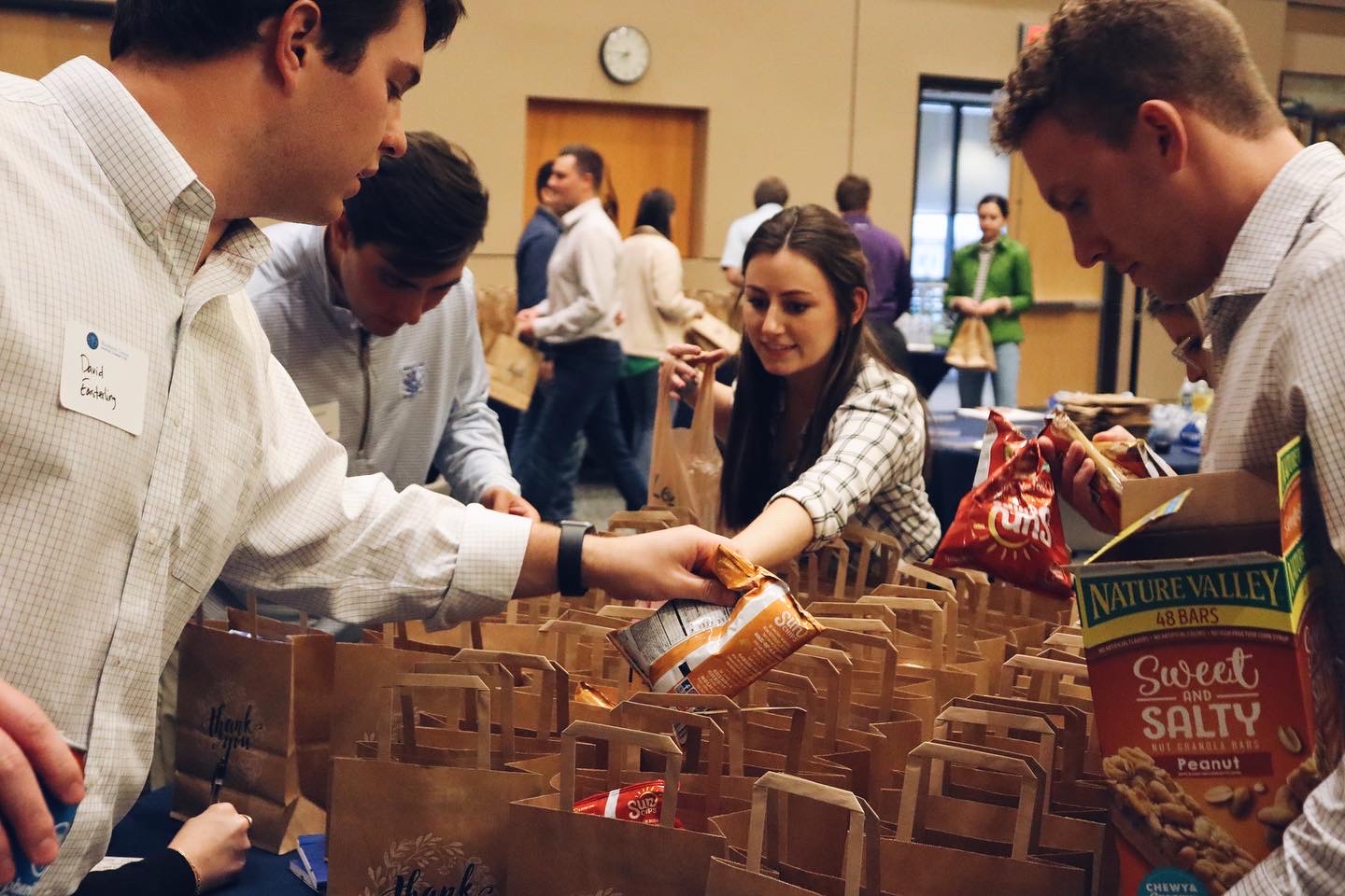 Shepherd Center Peach Corps volunteers putting snacks into paper bags