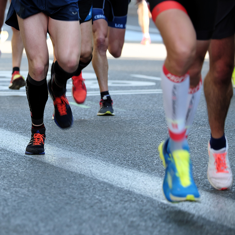 A close-up of runners' legs in motion as they participate in a race.